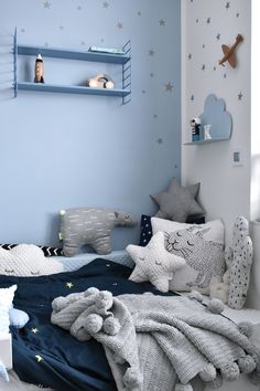 a child's bedroom with blue walls, stars and stuffed animals on the bed