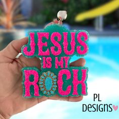 someone holding up a magnet that says jesus is my rock in front of a swimming pool