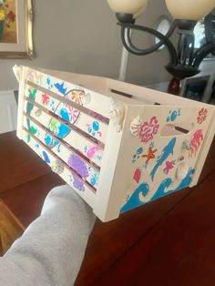 a person is holding a toy chest on top of a table