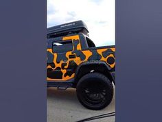 an orange and black truck is parked on the street