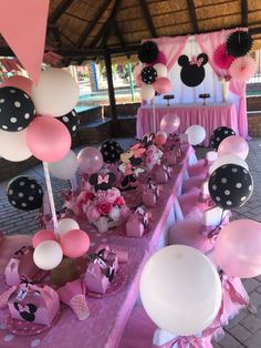 minnie mouse themed birthday party with pink and black decorations, balloons and tablecloths