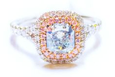 a fancy ring with an aqua blue diamond surrounded by multicolored diamonds