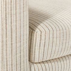 a close up view of the fabric on a chair with ticking lines in beige and white colors