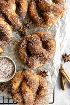 cinnamon sugar doughnuts on a cooling rack with cinnamon and star anise sprinkles