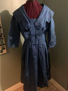 1950's cocktail dress in blue taffeta in a fit and flare style. Has large shawl collar with bow below bust. Fitted through waist with pleats that are open at the hip for fullness. The skirt has self covered buttons down center front. Sleeves are 3/4 length. Dress has a side seam for closure. The dress is in very good condition with a little wear under both arms and a slight discoloration at edge of collar Measurements  Bust 38 inches Waist 32 inches Skirt length 30 inches 1950s Cocktail Dress, Feb 7, Saint Louis, Shawl Collar, Dress Clothes For Women, Covered Buttons, Skirt Length, Fit And Flare, Shawl