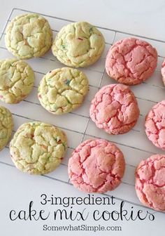 nine cookies are on a cooling rack with pink and green frosting, one is white