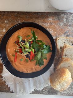 a bowl of soup with bread on the side