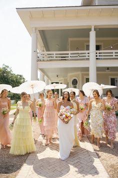 a group of women standing next to each other holding umbrellas in front of a building