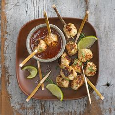 there are some food on the plate with chopsticks next to it and a bowl of sauce