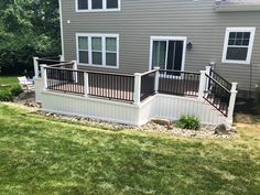 a house with a deck and railings in the front yard