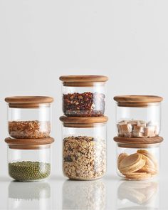 four glass jars filled with different types of food