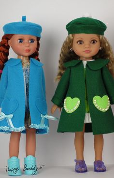 two dolls are standing next to each other wearing hats and coats with hearts on them