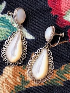 Mother of pearl Sterling silver (tested) Filigree Teardrop Dangle Screw back Great patina Substantial but not heavy - 7 grams each Materials: sterling silver, mother of pearl Measurements: Width at widest .5inch (1.27cm) Width at topmost 1 inch (2.54cm) Length 2inches (5.08cm) Weight 7 grams each Provenance: mid1940s, we believe Mexican artisan made Stamp: none 20220108J1066 Condition: Excellent vintage. No issues, chips or scratches. We gave a quick wipe with jewelry cloth and leave the remaini 1940s Jewelry, Czech Glass Necklace, Vintage Designer Jewelry, Tin Roof, Vintage Inspired Jewelry, Precious Jewels, Vintage Bride, Inspired Jewelry, Vintage Designer