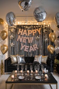 a living room filled with lots of silver and gold balloons next to a black couch