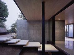 the interior of a modern house with concrete walls and floor to ceiling glass doors on both sides