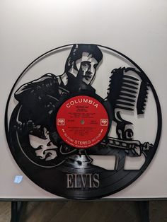 an elvis record with the name columbia on it and a man holding a microphone in his right hand