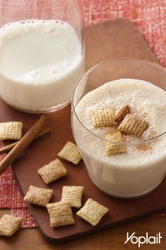 two glasses of milk and crackers on a cutting board