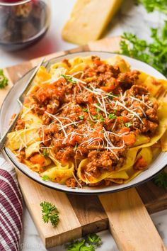 a plate of pasta with meat sauce and parmesan cheese