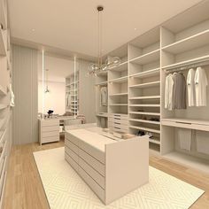 a large walk in closet with white shelves and drawers