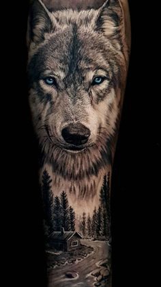 a man's leg with a wolf tattoo on it and trees in the background