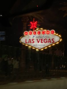 the welcome to las vegas sign is lit up in red and white lights at night