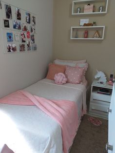 a small bedroom with pink and white decor