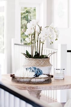 white flowers in a basket on top of a table