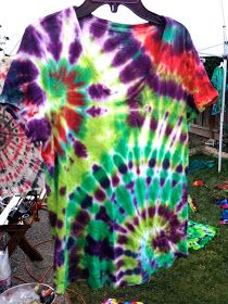 a tie - dyed shirt is hanging on a clothes line in front of other items