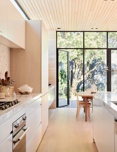 a kitchen with an oven, stove and table in it's center island area