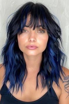 Ready to switch up your look and make a striking impression? Dive into the captivating realm of blue highlights! This bold hair trend has become a sensation in beauty circles, providing a unique and vibrant way to elevate your style. Whether you're aiming for a subtle hint of blue or full-on statement hues, these highlights are sure to add an exciting twist to your hairdo. Explore the endless possibilities and embrace this eye-catching trend to unleash your inner daring self! Blue Undertones Hair, Face Framing Highlights Colorful, Subtle Blue Hair Brunette, Orange And Blue Hair Ideas, Brunette And Blue Hair, Blue Shag Hair, Blue Hair With Dark Roots, Midnight Blue Balayage, Blue Hair Peekaboo