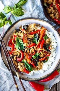 a white plate topped with rice covered in meat and veggies next to chopsticks