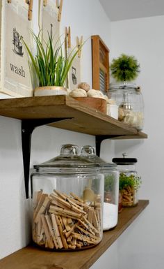 two shelves with jars and wooden dows on them, one holding plants and the other displaying herbs