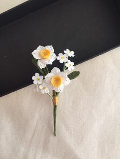 small crocheted flowers sitting in a black box