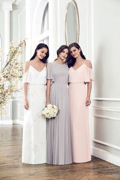 three bridesmaids in long dresses standing next to each other