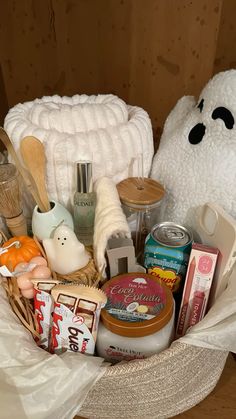 a white teddy bear sitting in a basket filled with food and confection items