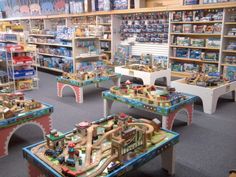 children's toys are on tables in a toy store with shelves full of books