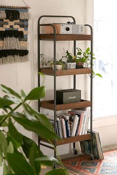 a bookshelf filled with lots of books next to a potted plant