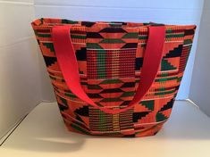 Kente fabric bucket tote bag.  Great for everyday, for shopping it can be used as a storage bag for bathroom items or cosmetics and for shopping.  Ships from Burlington, North Carolina.  The width across the top is 16 inches, the height is 11 inches and the depth on the side bottom in 4 inches.  African  cloth/fabric.  Great for a gift.  Great as a book bag or for a grocery bag, Burlington North Carolina, Fabric Bucket, Kente Fabric, Bucket Tote Bag, Bucket Tote, Bathroom Items, Cloth Fabric, Purse Strap, Book Bag