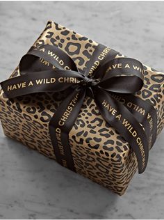 a gift wrapped in leopard print with a black ribbon