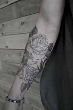 a black and white rose tattoo on the arm