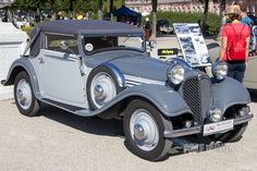 an old car is parked in front of a man