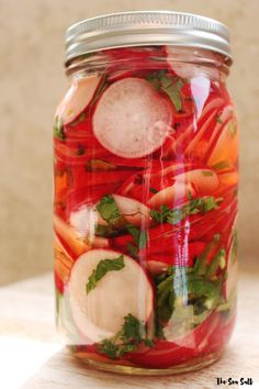 a jar filled with lots of veggies on top of a table