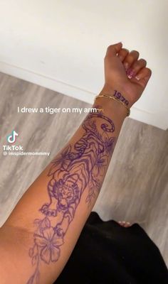 a woman's arm with tattoos on it and the words i draw a tiger on my arm