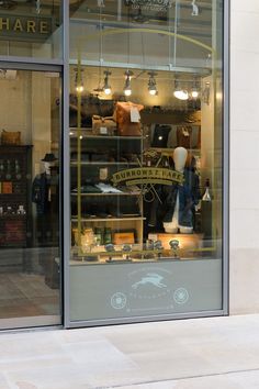 a store front window with an assortment of items in the display case and lights hanging from the ceiling