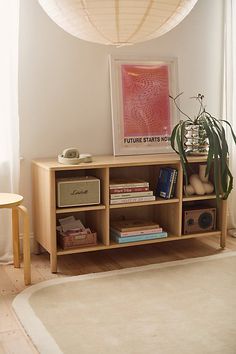 a living room with a book shelf filled with books and other items next to a window