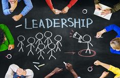 a group of people standing in front of a blackboard with the words leadership written on it