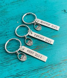 three personalized keychains with the names and date for each member on them