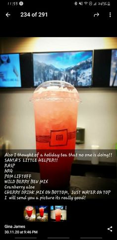 a red drink sitting on top of a table in front of tvs with the caption below it