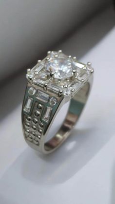 a diamond ring sitting on top of a white table next to a window sill