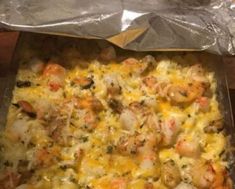 a casserole dish with shrimp and cheese in it